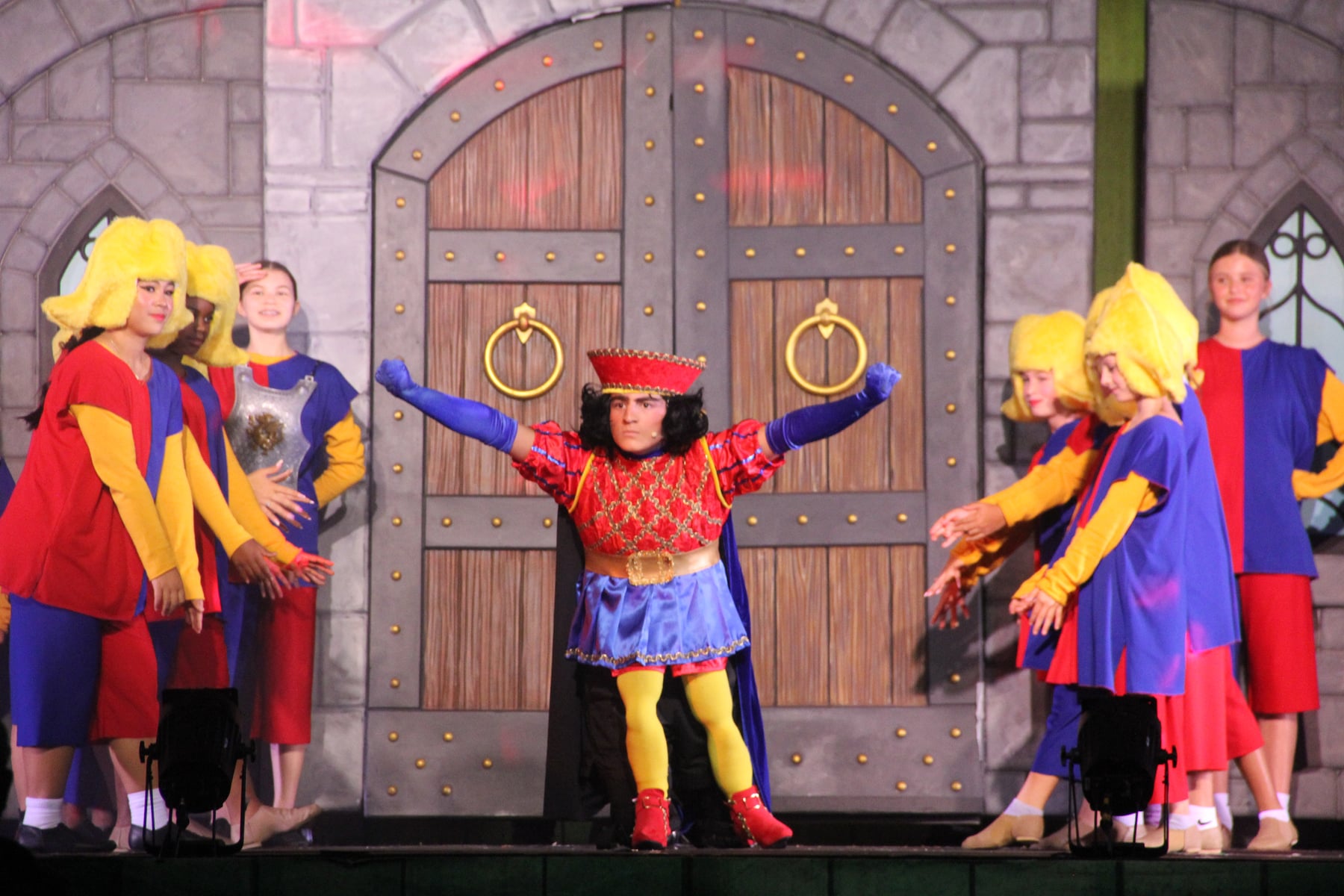 Child performers in costume onstage in a youth production of Shrek The Musical Jr.