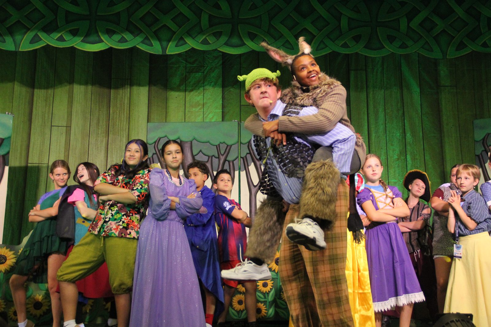 Shrek lifting Donkey during the finale with the full cast