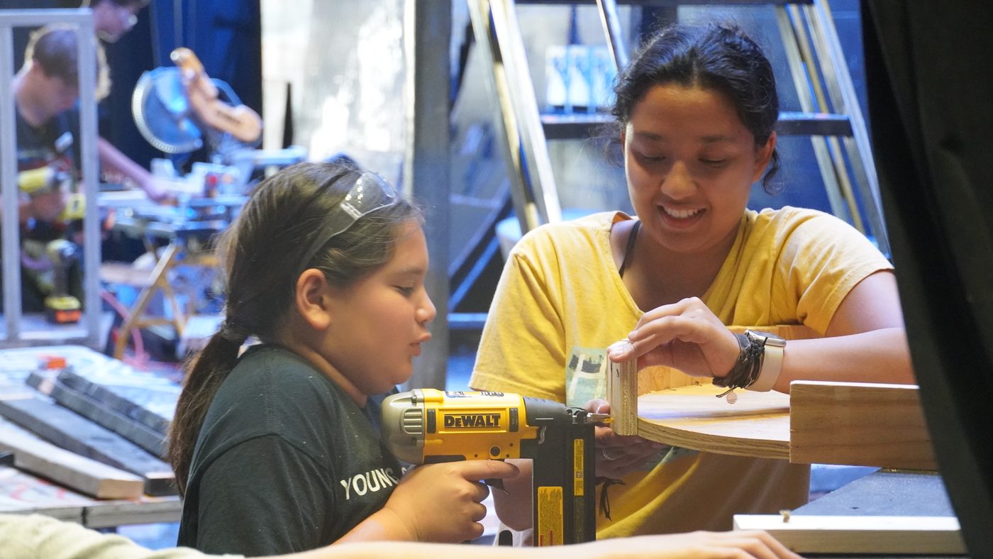 A camper building set pieces alongside a mentor
