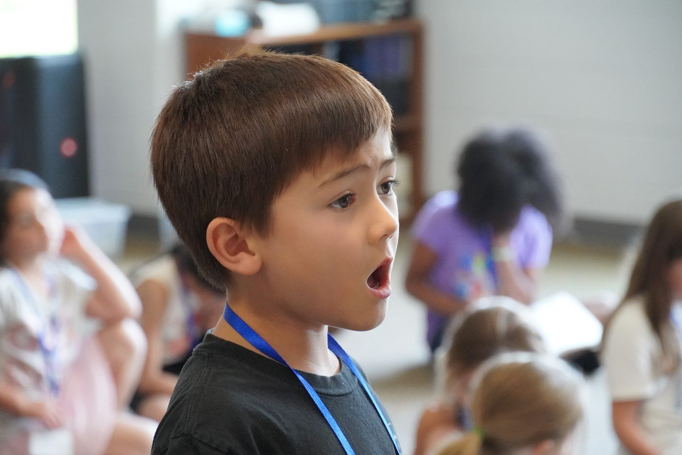 A young camper singing during a vocal rehearsal